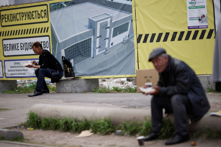 2022 年 5 月 4 日、ウクライナのザポリージャで、ロシアがウクライナに侵攻する中、人々が寄付金の収集場所に立つ中、食事をするウクライナの避難者。