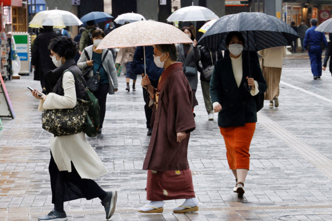 東京の商店街を歩く伝統衣装を着た女性