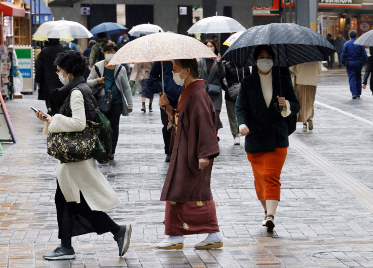 東京の商店街を歩く伝統衣装を着た女性