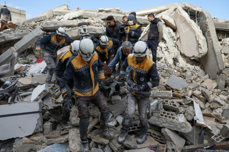 シリアの反政府勢力が支配する北西イドリブ州のアズマリン村で、地震による死傷者とともに瓦礫から救出されたホワイト ヘルメットの救助隊員