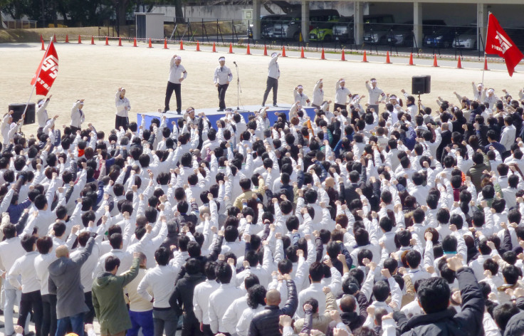 トヨタ自動車の労働組合のメンバーは、豊田市の会社本社で毎年恒例の「春闘」賃金交渉の集会でスローガンを叫びながら拳を上げます。