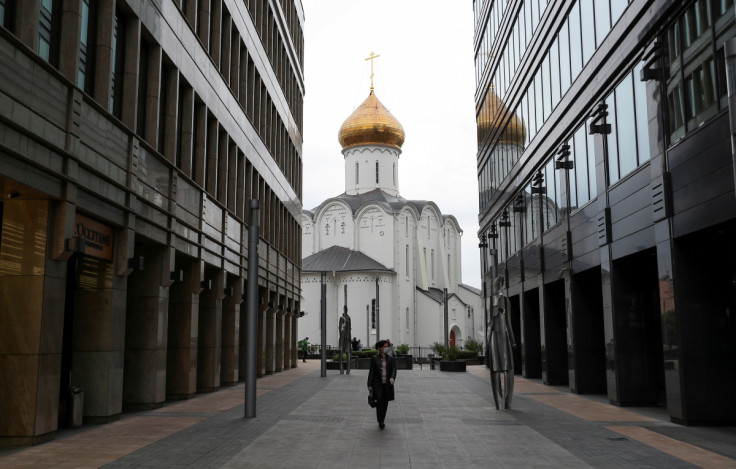 防護マスクを着用した女性がモスクワのビジネス街を散歩している