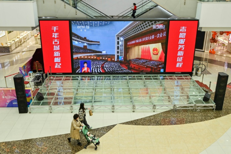全国人民代表大会 (NPC) の開会セッションの生中継が、中国の青州にあるショッピング モールで放映されました。