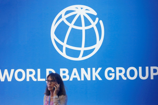 国際通貨基金 - ヌサドゥアで開催された 2018 年世界銀行年次総会で、世界銀行のロゴの近くに立つ参加者