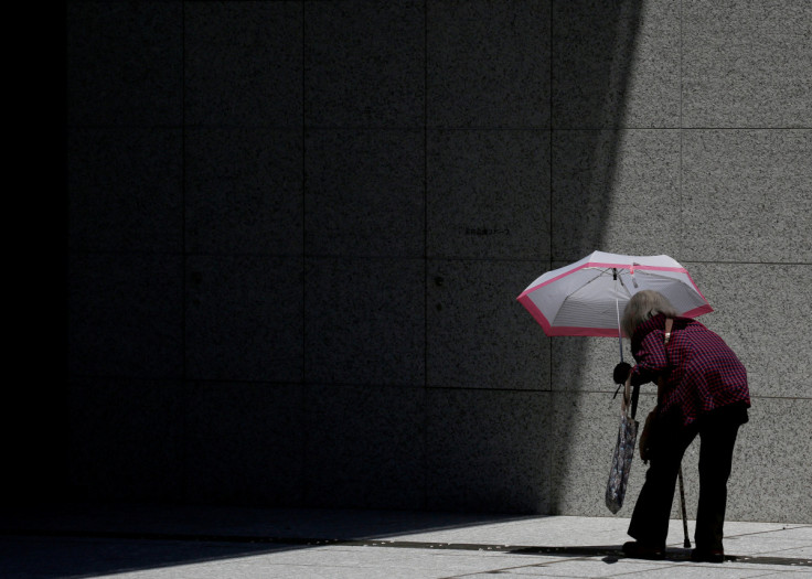 日傘をさして東京の商業ビルに入る女性