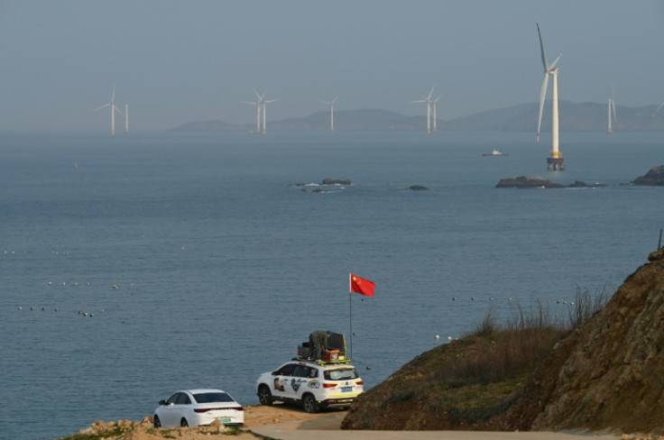 車に中国国旗を掲げ、中国が実弾演習を行うと発表した海域に向かって台湾海峡の眺めを眺める準備をしている男性