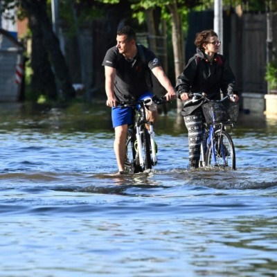2023年5月21日、ラヴェンナ近郊のコンセリセで、冠水した道路を自転車に乗って渡る住民たち。