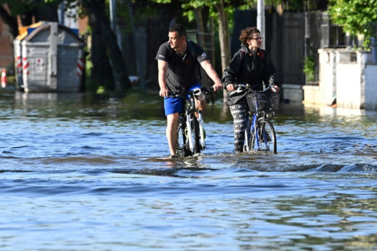 2023年5月21日、ラヴェンナ近郊のコンセリセで、冠水した道路を自転車に乗って渡る住民たち。