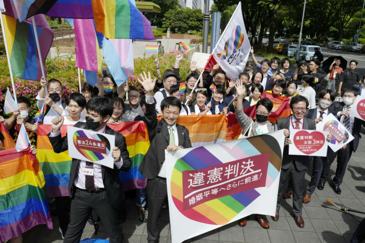 名古屋地方裁判所の外で、下級裁判所が同性婚を認めないことは違憲であるとの判決を下した後、原告の弁護士を含む人々が横断幕や旗を掲げる