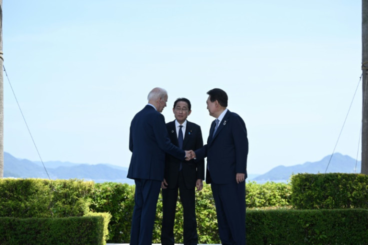 2023年5月21日に広島で開催されたG7首脳サミット中に挨拶する米国のジョー・バイデン大統領、日本の岸田文雄首相、韓国の尹錫悦大統領