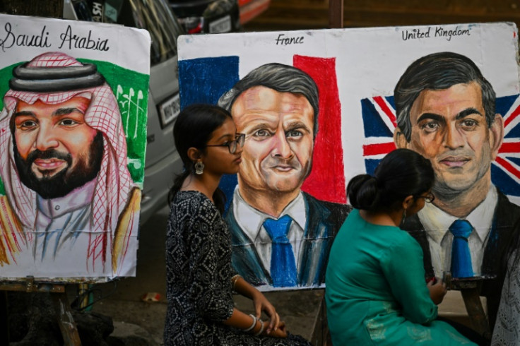 G20サミットを前に、サウジアラビアのムハンマド・ビン・サルマン皇太子、フランスのエマニュエル・マクロン大統領、英国のリシ・スナック首相（左から）の絵に最終仕上げをする学生たち