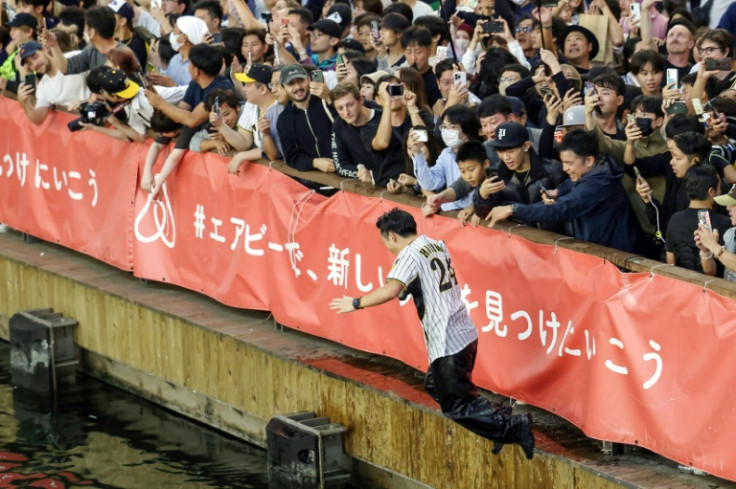 阪神タイガースが日曜日に日本シリーズで優勝した後、阪神タイガースのファンが大阪の道頓堀川に身を投げた